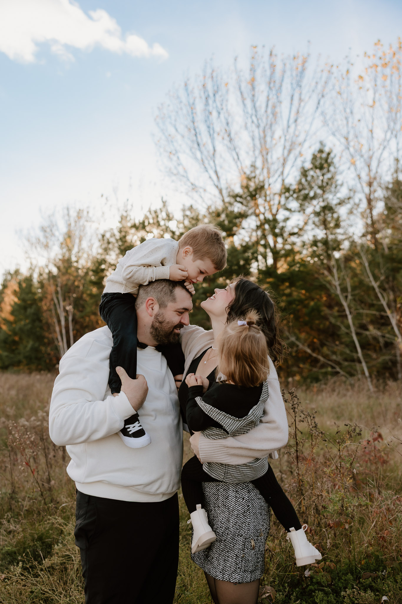 Family embracing at golden hour during a cozy fall photography session in Sudbury